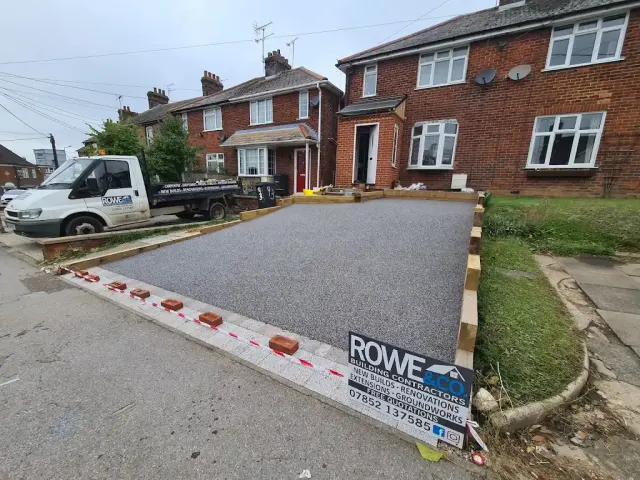 Freshly laid grey resin driveway with timber edging still in place