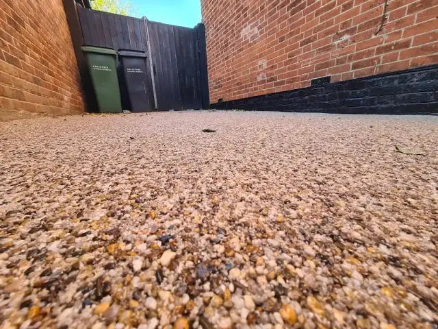 Close-up of buff resin bound aggregate laid through a side passage