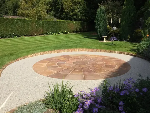 Circular sandstone paving feature set into a cream resin garden terrace