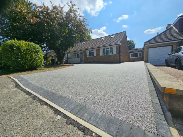 Silver resin driveway across the full frontage of a bungalow